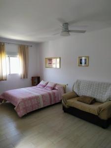 a bedroom with a bed and a couch at Apartamento en Olvera in Olvera