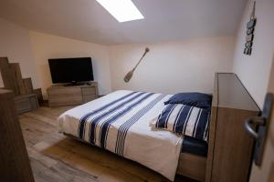 a bedroom with a bed and a flat screen tv at Entre Terre et Mer in Marsillargues