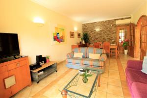 ein Wohnzimmer mit einem Sofa und einem TV in der Unterkunft Vilamoura MiraGolf With Pool by Homing in Vilamoura