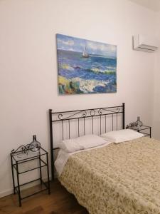 a bedroom with a bed and a painting on the wall at La casa nel Borgo in Scopello