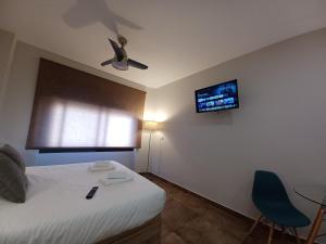 1 dormitorio con 1 cama y ventilador de techo en Apartamento Luxury Triana-Los Remedios, en Sevilla