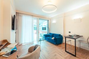 ein Wohnzimmer mit einem blauen Sofa und einem Tisch in der Unterkunft Casitta Suite in Taormina