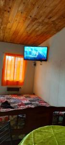 a bedroom with a bed with a television on the wall at La casita del parque in Mar del Plata