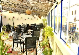 a patio with tables and chairs in a restaurant at Appart, Hotel & Café Agadir in Essaouira