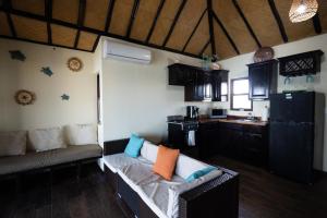 a living room with a couch and a kitchen at Lina Point Belize Overwater Resort in San Pedro