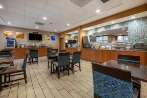 a restaurant with tables and chairs and a cafeteria at Comfort Inn & Suites Orlando North in Sanford