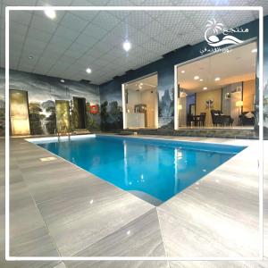 una gran piscina de agua azul en un edificio en منتجع نون الفندقي en As Sayl aş Şaghīr