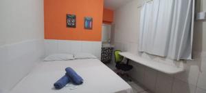 a small room with a bed with a blue item on it at Casa Recife Pousada in Recife +172 photos