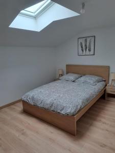 a bedroom with a bed in a room with a skylight at Charmante maison a la ferme in Bonnes