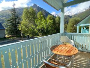 a table and chairs on a porch with mountains at Joli chalet 60m2 proche du centre. parking. balcon in Cauterets