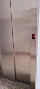 a metal elevator with a red light on it at The Summer Treat Shared Apartment Compartido in Corralejo