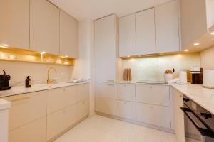 uma cozinha branca com armários e electrodomésticos brancos em Le Haras 3 bedroom apartment in the heart of Annecy em Annecy