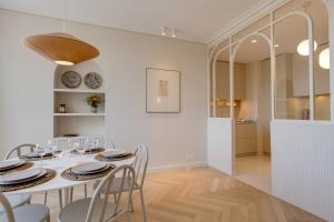 uma sala de jantar branca com uma mesa e cadeiras brancas em Le Haras 3 bedroom apartment in the heart of Annecy em Annecy