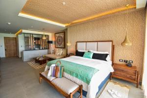 a bedroom with a large bed and a living room at Mvngata Beach Hotel in Playa del Carmen