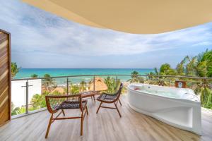 a bath tub on a balcony with a view of the ocean at Mvngata Beach Hotel in Playa del Carmen