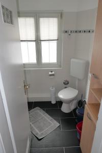 Un baño blanco con inodoro y ventana. en Bodensee Loge, en Radolfzell am Bodensee 8 fotos más