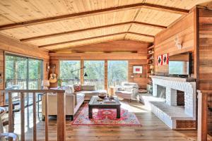 a living room with wooden ceilings and a fireplace at Groveland Cabin with Outdoor Perks and Game Room in Groveland