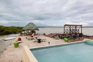 a resort with a swimming pool next to the water at Lina Point Belize Overwater Resort in San Pedro