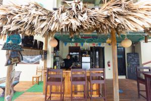a restaurant with a bar with a straw umbrella at Lina Point Belize Overwater Resort in San Pedro