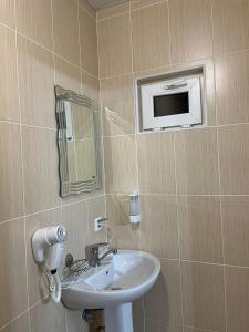 La salle de bains est pourvue d'un lavabo et d'un miroir. dans l'établissement Guest House Esma, à Soukhoumi