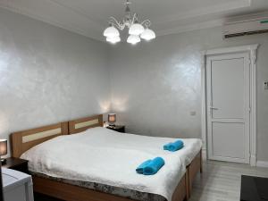 a bedroom with a bed with blue pillows on it at Guest House Esma in Sukhum