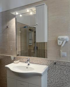 ein Bad mit einem Waschbecken und einem Spiegel in der Unterkunft B&B felix in Porto Cesareo