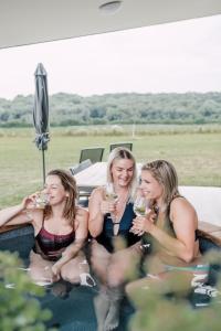 three women sitting in the back of a truck drinking wine at Landgoed Moerslag in Sint Geertruid