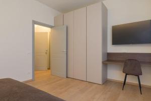 - une chambre avec une télévision murale et une chaise dans l'établissement Room Castelvecchio, à Vérone