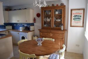 a kitchen with a wooden table and a dining room at Cedra Cottage - Vintage Country Hideaway in Axminster