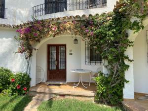 einen Torbogen mit einem Tisch und Blumen vor einem Haus in der Unterkunft Apartamento Urb Oasis Park II Denia, las Marinas in Denia