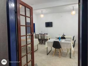 a dining room with a white table and chairs at Repouso Clave de Sol in Paraty