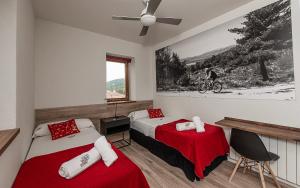 Un dormitorio con dos camas y un ventilador de techo. en CicloLodge, en Lozoya