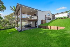 a house with a large yard with green grass at 24 Hibiscus Crescent Port Macquarie in Port Macquarie