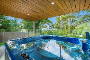 a hot tub in a backyard with a wooden ceiling at 24 Hibiscus Crescent Port Macquarie in Port Macquarie