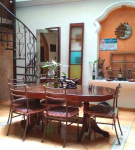 een eettafel met stoelen en een spiegel bij Hotel Villa Florencia Centro Histórico in San Salvador