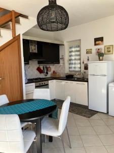 een keuken met een zwarte tafel en witte stoelen bij Cactus 2020 in Sabaudia
