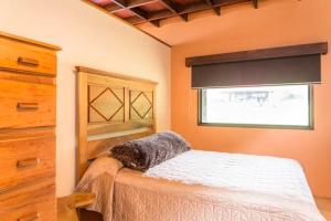 a bedroom with a bed and a window at Coffee Garden Ranch Costa Rica in Concepción