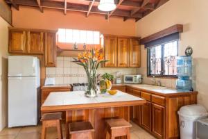 a kitchen with wooden cabinets and a vase of flowers at Coffee Garden Ranch Costa Rica in Concepción +47 photos
