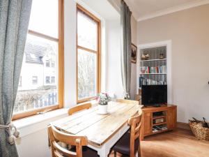 a dining room with a wooden table and a window at Aultmore in Kingussie