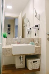 a bathroom with a sink and a mirror at Apart-hotel TrueAmérica in Campos dos Goytacazes