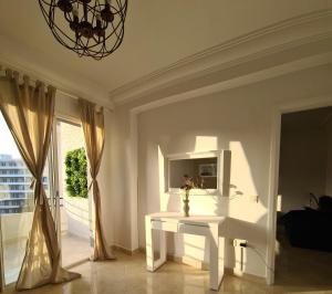 - une table blanche dans une chambre avec fenêtre dans l'établissement Superbe Appartement à 2 Min de la gare de Tanger et à 5 min de la plage Malabata, à Tanger