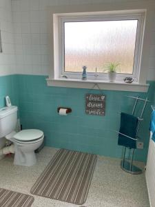 a bathroom with a toilet and a window at The Waterside Apartment 6 in Largs