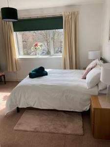 a bedroom with a large white bed with a window at The Waterside Apartment 6 in Largs