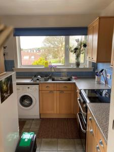a kitchen with a sink and a washing machine at The Waterside Apartment 6 in Largs