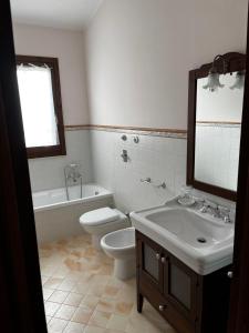 a bathroom with a sink and a toilet and a tub at Villetta Vista Mare Cornino in Custonaci
