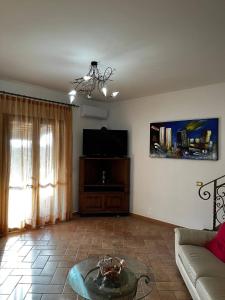 a living room with a couch and a tv at Villetta Vista Mare Cornino in Custonaci