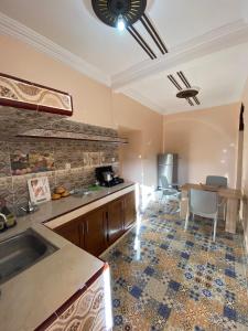 a kitchen with a sink and a table in a room at Résidence AGDAL in Dakhla