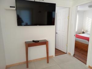 a bedroom with a bed and a television on a wall at Casa Interior en La Cruz Quillota in Quillota