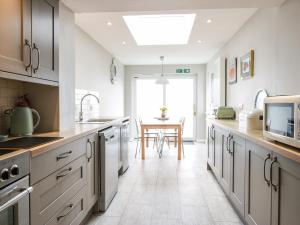 una grande cucina con armadi bianchi e tavolo di The Anchorage a Cockburnspath