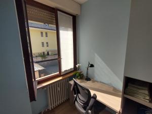 Zimmer mit einem Fenster mit einem Stuhl und einem Heizkörper in der Unterkunft La Casa del Birraio in Sondrio